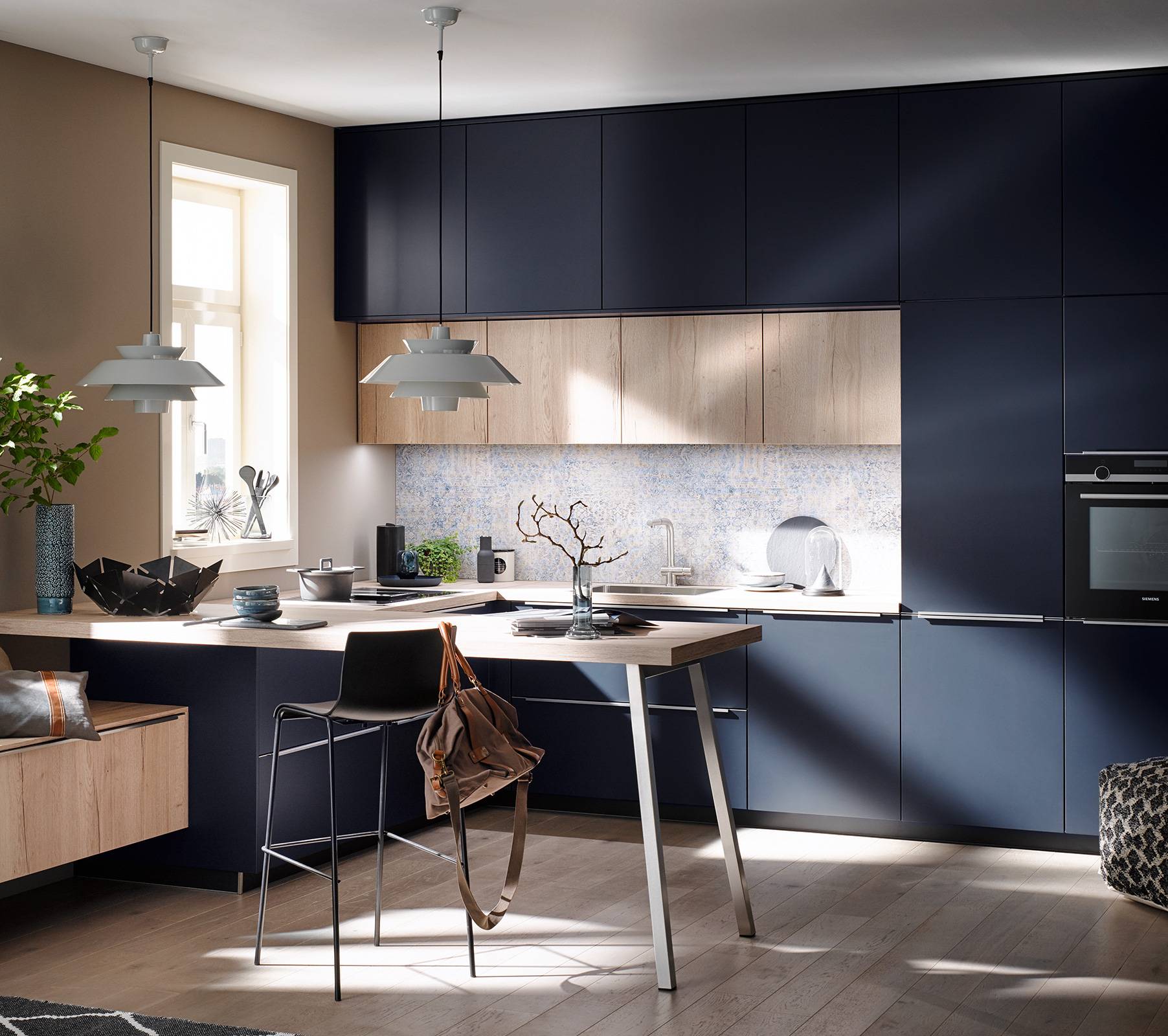 Dunkelblaue Küche mit beleuchteter Rückwand und Theke in Holzoptik